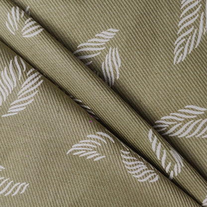 unstitched fabric with white leaf pattern on a green background